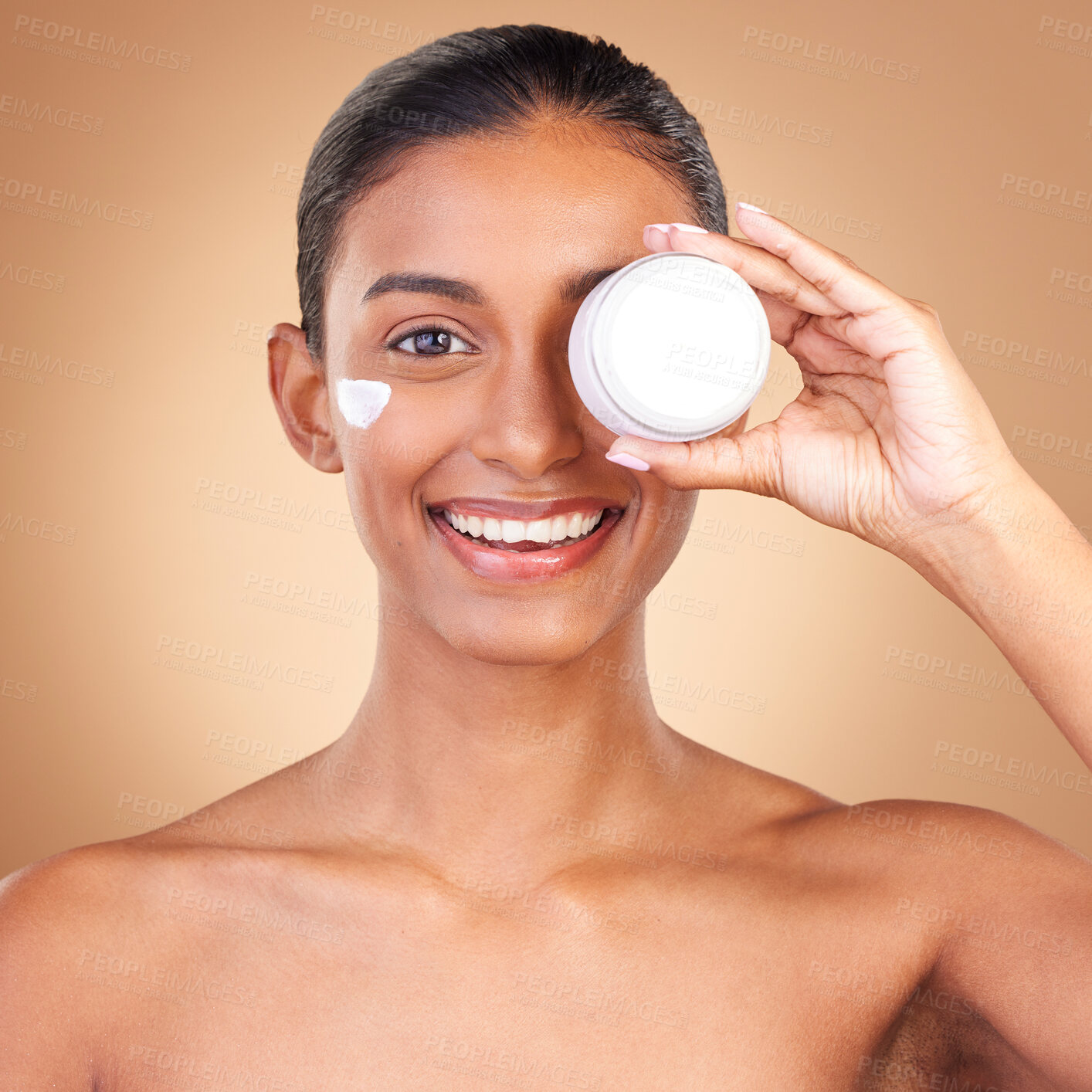 Buy stock photo Indian woman, skincare cream and jar in portrait with smile, happiness and wellness by brown background. Happy model, lotion product and face in studio for dermatology, aesthetic and cosmetic beauty