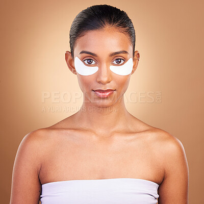 Buy stock photo Skincare, eye patch and portrait of Indian woman in studio for facial, spa treatment and glow. Self care, cosmetics and hydration with female model on brown background for mask, product and youth