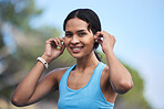 Fitness, woman and portrait smile with earphones for running, exercise or cardio workout in nature. Happy fit female runner smiling and listening to music on earpieces for audio track and exercising