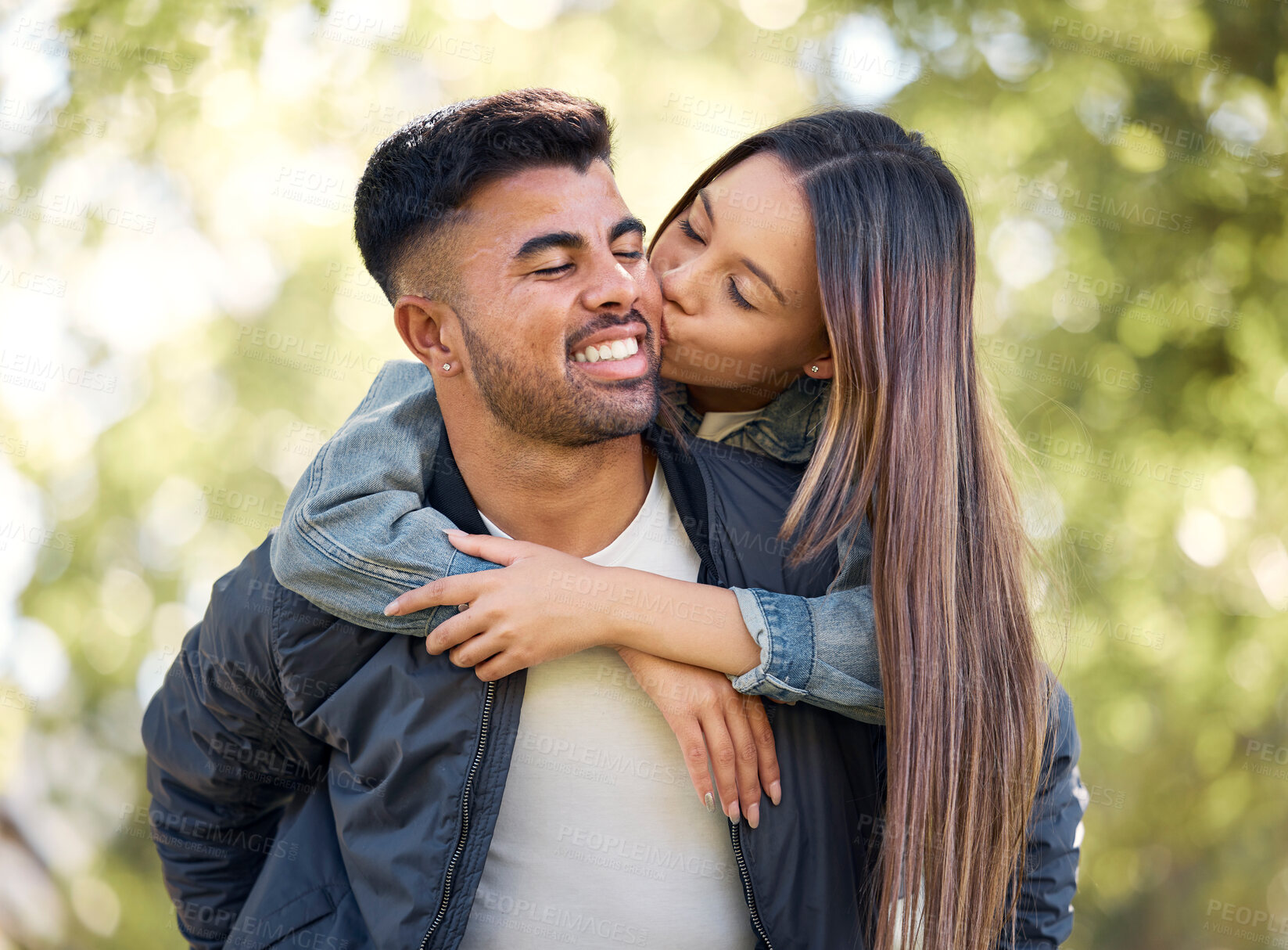 Buy stock photo Couple, outdoor and piggyback with kiss for love, care and happiness together in summer. Young man and woman at nature park for affection, play or game on happy and romantic date or vacation to relax