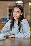 Cafe, relax and portrait of woman with coffee in restaurant with hot beverage, cappuccino and latte drink. Happy, smile and face of girl sitting by table for calm, relaxation and happiness on weekend