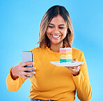 Woman, cake and studio with a selfie and smile for social media while excited to eat. Happy female on blue background with rainbow color dessert for influencer birthday celebration profile picture
