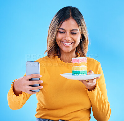 Buy stock photo Woman, cake and studio with a selfie and smile for social media while excited to eat. Happy female on blue background with rainbow color dessert for influencer birthday celebration profile picture