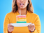 Birthday cake, celebration and blowing a candle to celebrate a gift or present isolated in a studio blue background. Dessert, sweet and woman or person excited, happiness and happy for festive
