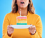 Birthday cake, celebration and blowing a candle to celebrate a gift or present isolated in a studio blue background. Dessert, sweet and woman or person excited, happiness and happy for festive