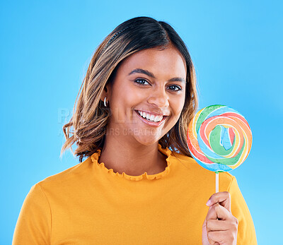 Buy stock photo Portrait, lollipop and a woman on a blue background in studio wearing heart glasses for fashion. Smile, candy and sweet with an attractive young female eating a giant snack while feeling happy