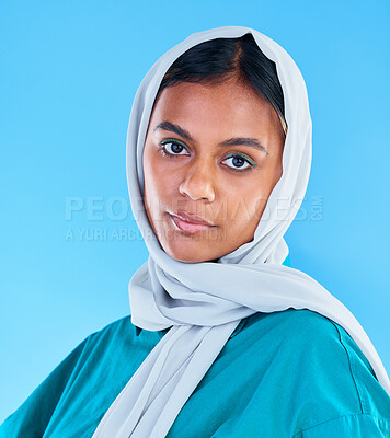 Buy stock photo Muslim, serious woman and portrait with scarf on blue background, studio and backdrop. Young female model, islamic culture and beauty of empowerment, proud religion or arabic fashion of elegant hijab