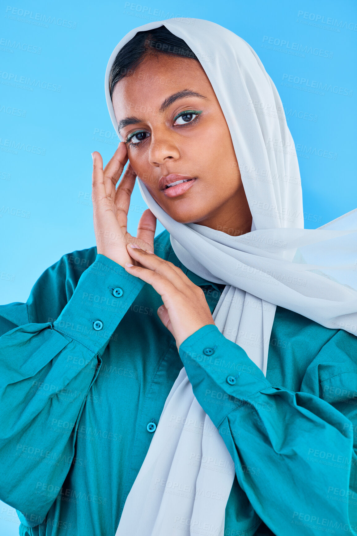 Buy stock photo Muslim, woman and serious portrait in studio, blue background and color backdrop. Young female model, islamic culture and beauty of empowerment, proud religion and arabic fashion of elegant hijab 