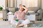 Tired woman, housekeeping and detergent from spring cleaning services in living room on floor at home. Exhausted female maid or cleaner in burnout, stress or fatigue for routine maintenance in lounge