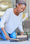 Maid, housekeeping and black woman cleaning and sweeping floor of a living room in a home or house for hygiene. Housekeeper, cleaner and domestic female remove dirt or dust with hand broom