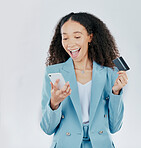 Phone, credit card and online shopping with a woman customer in studio on a gray background feeling excited. Ecommerce, sale and payment with a happy female shopper enjoying retail spending