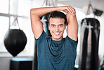 Portrait, stretching arm and man in gym ready to start workout, training or exercise. Sports smile, health fitness and happy male athlete warm up, stretch or prepare for exercising for flexibility.