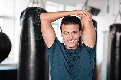 Portrait, stretching arm and man in gym ready to start workout, training or exercise. Sports smile, health fitness and happy male athlete warm up, stretch or prepare for exercising for flexibility.