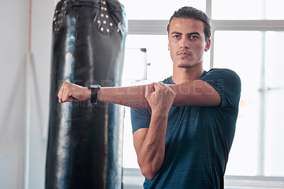 Buy stock photo Serious, stretching arm and man in gym ready to start workout, training or exercise. Sports fitness, thinking and young male athlete warm up, stretch arms or prepare for exercising for flexibility.