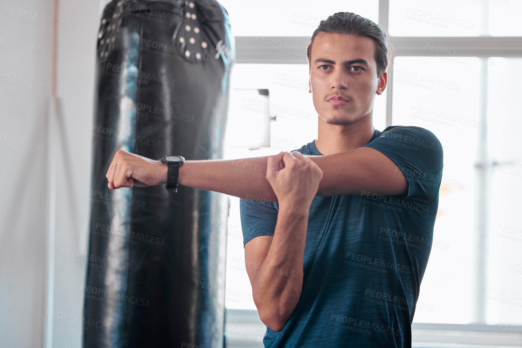 Buy stock photo Serious, stretching arm and man in gym ready to start workout, training or exercise. Sports fitness, thinking and young male athlete warm up, stretch arms or prepare for exercising for flexibility.