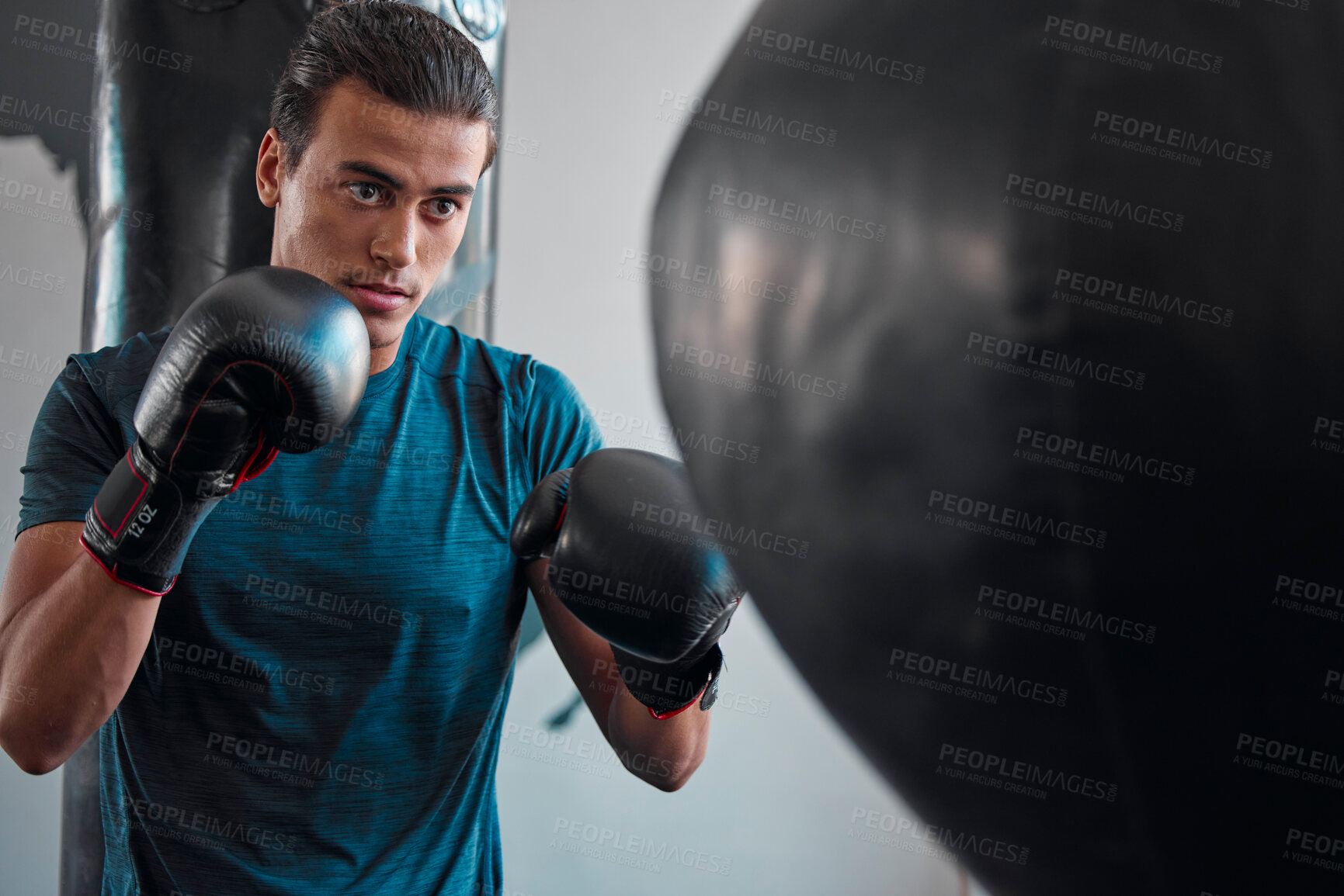 Buy stock photo Sports, boxing and man with punching bag in gym for training, exercise or workout. Boxer, fitness athlete and serious fighter punch for fight, competition or practice, health or wellness for strength