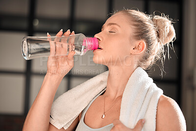 Athlete, fitness and woman drinking water in gym after workout, training or exercise. Sports, nutrition and thirsty athletic female drink liquid aqua from bottle for hydration, health and wellness.