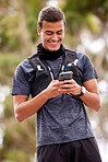 Fitness, man and phone with smile for social media, communication or chatting in nature. Happy active male smiling on mobile smartphone for chat, texting or networking after outdoor workout exercise