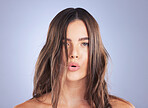 Beauty, woman and hair care portrait in studio for texture, growth and healthy shine on blue background. Aesthetic female face for haircare, makeup and cosmetic results for salon or hairdresser curls