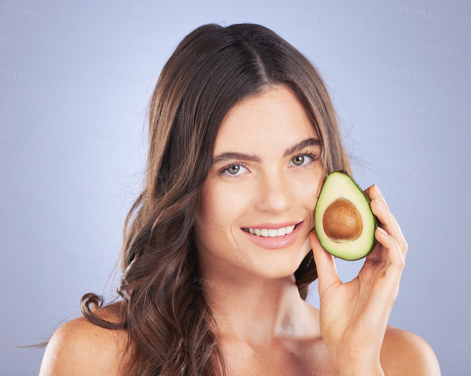 Buy stock photo Woman, avocado and skincare in studio portrait with smile, organic cosmetics and nutrition for beauty. Girl, model and fruit for cosmetic, skin and natural healthy glow with pride by blue background