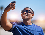 Fitness, selfie and man runner with phone outdoors for training, running or exercise on blurred background. Happy, guy and social media health influencer smile for photo, profile picture or blog post