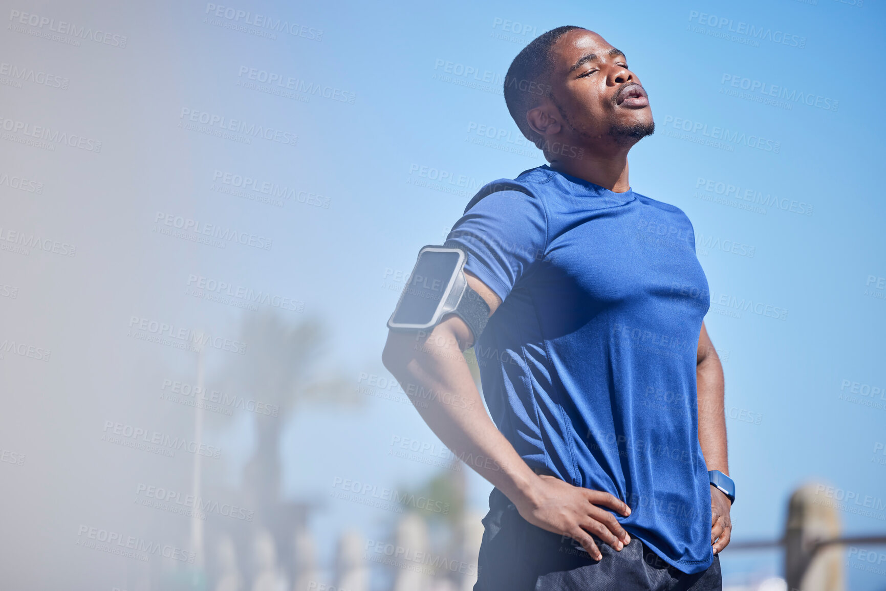 Buy stock photo Fitness, exercise and tired man runner outdoors for break from training, cardio or running on blue sky background. Workout, stop and breathe by athletic guy outside for marathon, run or sport routine