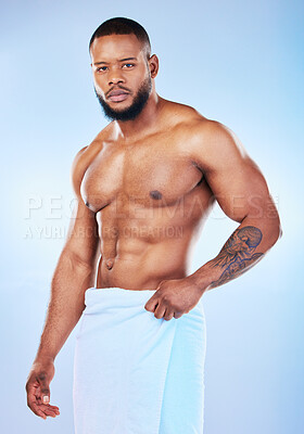 Buy stock photo Black man, portrait and body with a towel in studio for health, wellness and fitness. Face of serious male aesthetic model for clean body, strong muscle and skincare on a gradient blue background