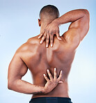 Back, strong and black man with muscle touching his spine as self love, skincare and isolated in a studio blue background. Health, wellness and strong muscular male model embracing skin