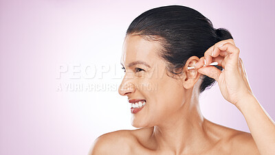 Buy stock photo Woman, cotton and clean ear in studio with happiness for wellness, health and pink background. Model hand, self care and cleaning for hygiene, earwax and natural product with smile by background