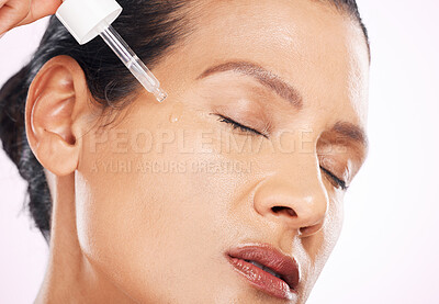 Buy stock photo Face, skincare serum and woman with eyes closed in studio isolated on a purple background. Dermatology, cosmetics and mature female model apply hyaluronic acid, retinol or essential oil for antiaging