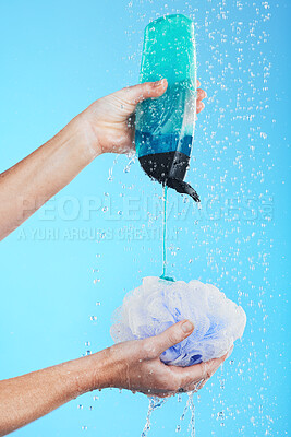 Buy stock photo Skincare, product and hands with loofah and shower gel of person washing isolated in a studio blue background. Self care, beauty and person or model using soap and sponge for morning routine