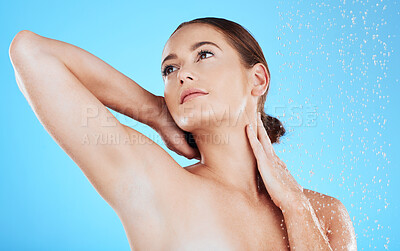 Buy stock photo Water drops, shower and woman washing in studio for skincare, wellness and clean body for self care. Face of female aesthetic model with splash for cleaning, hygiene and cosmetics on blue background