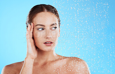 Buy stock photo Shower, water and woman thinking in a studio feeling relax from cleaning or natural skincare. Wellness, wet or beauty routine of female model with facial dermatology and self care on blue background