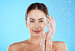 Shower portrait, water and woman in a studio feeling happy from cleaning and skincare. Wellness, splash and beauty routine of a female model with dermatology and self care with blue background