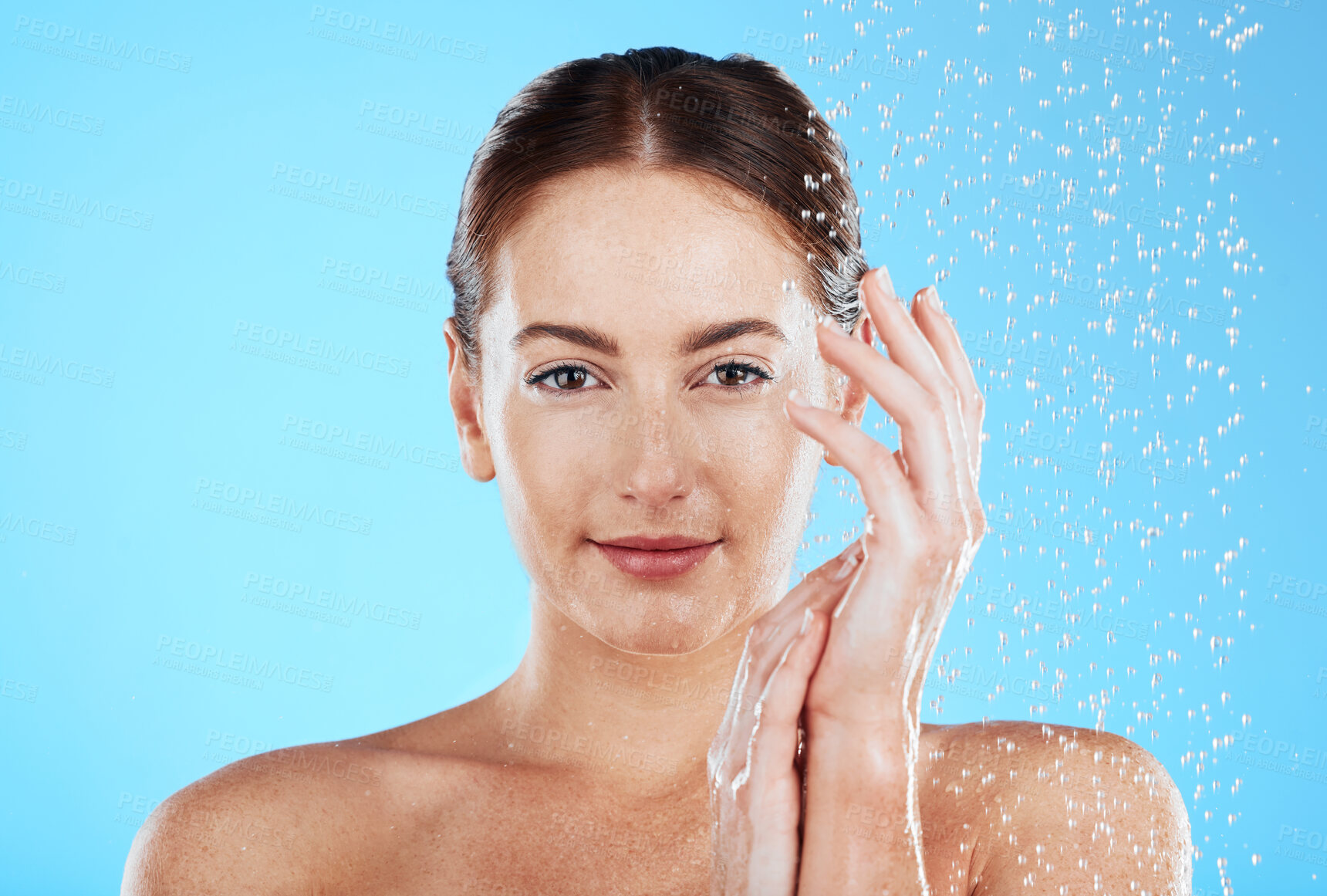 Buy stock photo Shower portrait, water and woman in a studio feeling happy from cleaning and skincare. Wellness, splash and beauty routine of a female model with dermatology and self care with blue background