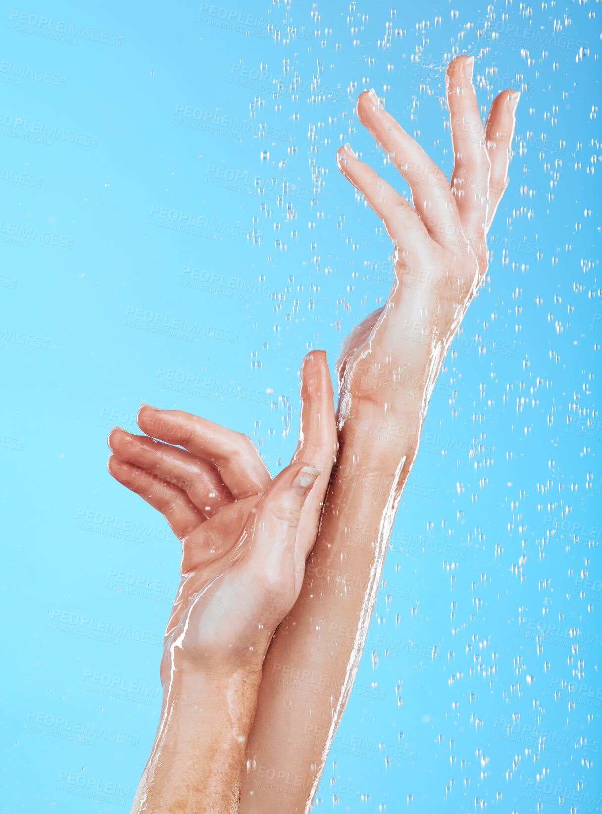 Buy stock photo Closeup woman, water drops and washing hands on blue background, studio backdrop or sustainability skincare. Female model, hand and liquid for showering, cleaning and beauty of dermatology wellness