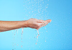 Woman hands, cleaning and water in a studio for skincare, safety and healthcare from virus. Isolated, blue background and hand wash for hygiene wellness and sanitary protection with liquid stream 