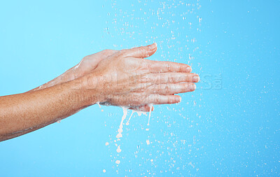 Buy stock photo Closeup woman, water drops and washing hands on blue background, studio and backdrop for sustainability. Female model cleaning hand with liquid for showering, wellness and skincare of hygiene routine