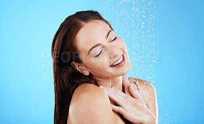 Buy stock photo Water drop, shower and happy woman washing her body, skincare and self care isolated in a studio blue background. Aqua, beauty and female model cleaning her skin as wellness feeling calm and relaxed