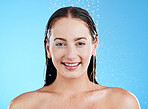 Shower, water and portrait of a happy woman in a studio  from cleaning and skincare. Wellness, cosmetics and beauty routine of a female model with dermatology and self care with blue background