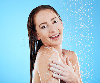 Buy stock photo Shower, soap and woman portrait in a studio feeling happy from cleaning and skincare. Wellness, splash and beauty routine of a female model smile from dermatology and self care with blue background