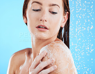 Buy stock photo Shower soap, woman and body cleaning in a studio with a female washing for beauty routine. Water, model and wellness of a young person in bathroom for self care and dermatology with blue background