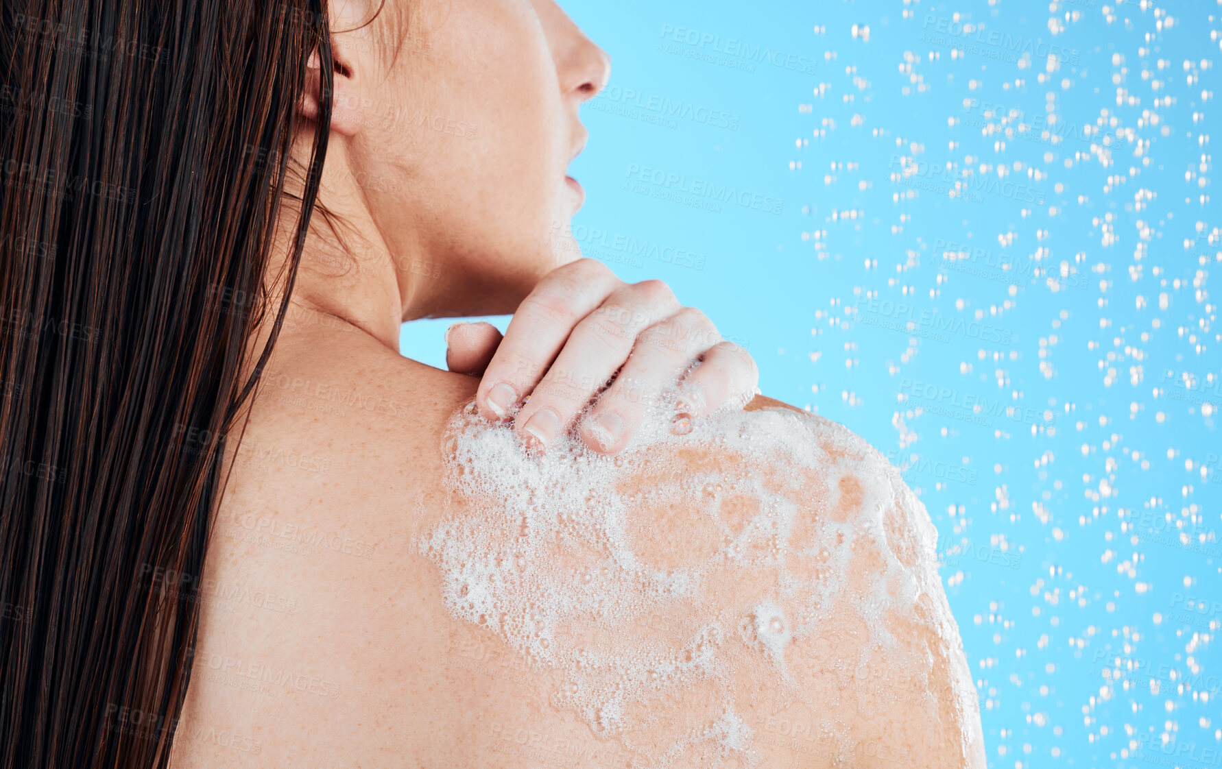 Buy stock photo Shower, woman hands and back washing in a studio with a female bodycare for beauty routine. Water, model and wellness of young person cleaning with soap for hygiene and grooming with blue background