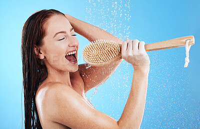 Buy stock photo Shower singing, skincare and woman with happiness and fun in a studio. Bathroom, music and happy female model with isolated blue background and cleaning brush karaoke for beauty routine and wellness