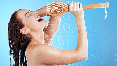 Buy stock photo Shower karaoke, skincare and woman with happiness singing in a studio. Bathroom, music and happy female model with isolated blue background and cleaning brush for beauty routine and wellness