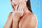 Woman face cleaning, shower water and studio with a young female hands doing skincare. Bathroom, dermatology beauty and facial treatment of a model hand with mock up and isolated blue background