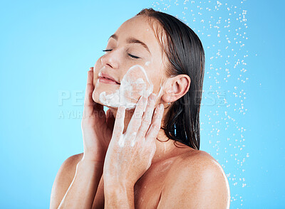 Buy stock photo Shower, facial and woman washing face with soap on blue background for grooming, cleaning and wellness. Skincare, bathroom and happy girl with foam product for hygiene, hydration and beauty in studio