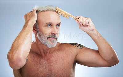 Buy stock photo Mature man, brush hair and scalp treatment in a studio with a male model doing beauty routine. Wellness lifestyle, hairstyle care and barber and hairdresser comb with an isolated grey background 