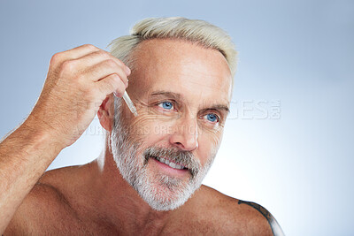 Buy stock photo Old man, smile and facial oil for skincare, beauty and grooming, apply serum on face against studio background. Dropper, anti aging cosmetic care with senior male and mockup, hygiene with dermatology