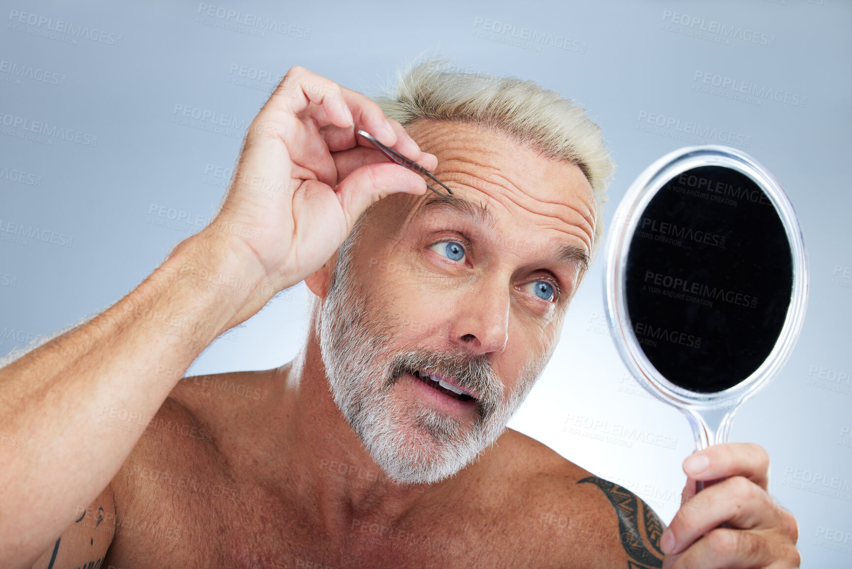 Buy stock photo Senior man, tweezers and eyebrow in studio with mirror, grooming and self care for beauty by background. Model, check and tweezing for facial hair removal, cleaning and elderly cosmetics by backdrop